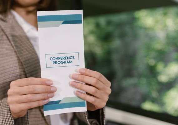 a woman holding a conference program